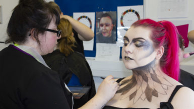Picture of our student doing the makeup on her model